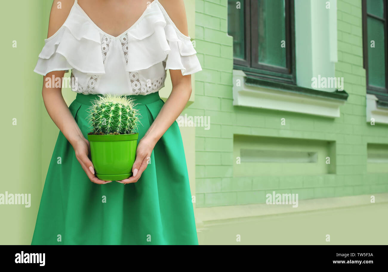 Hipster Frau in grün Rock holding Kakteen im Freien Stockfoto