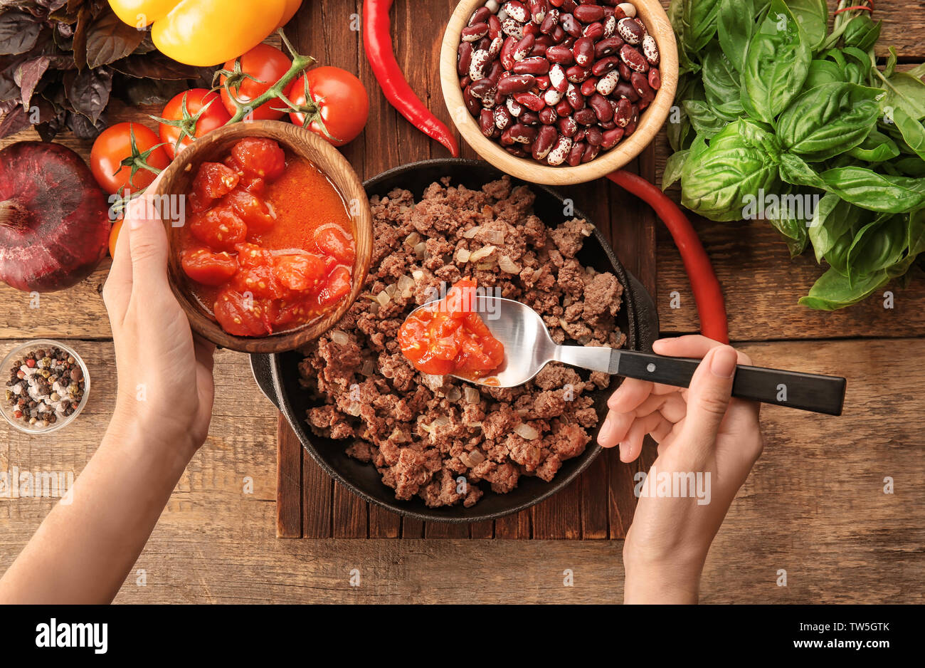 Frau hinzufügen Tomatensauce mit Hackfleisch zubereitet in der Küche Stockfoto
