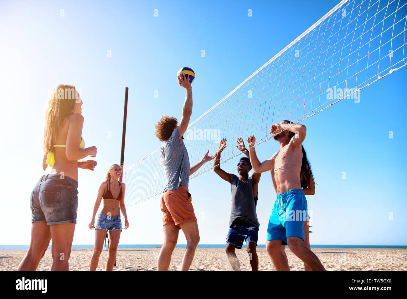 Gruppe von Freunden zu Beach-Volleyball am Strand spielen Stockfoto
