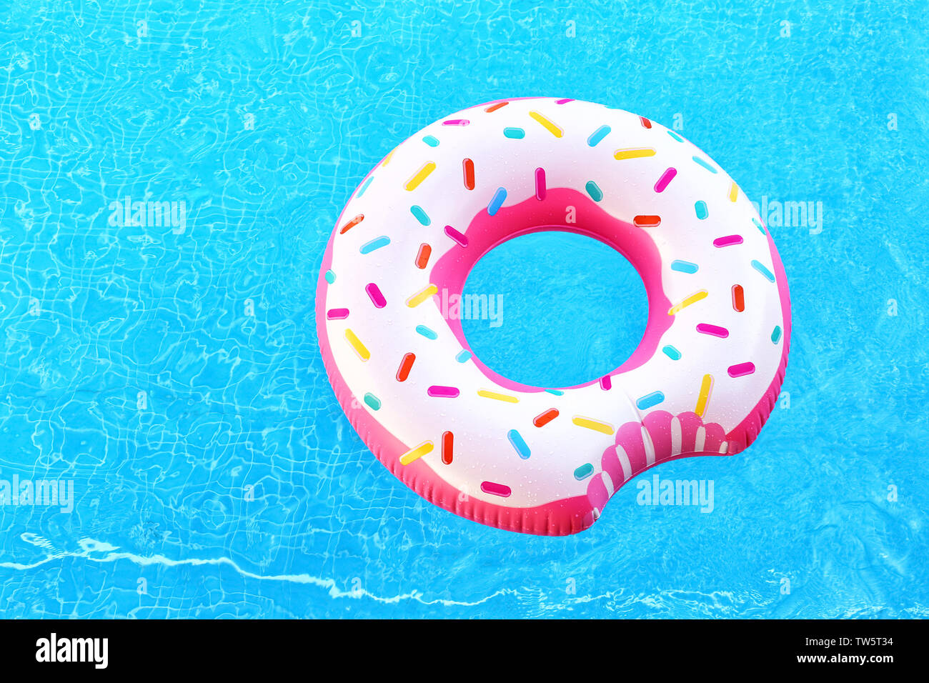 Bunte Aufblasbare Donut in blauen Pool Stockfoto