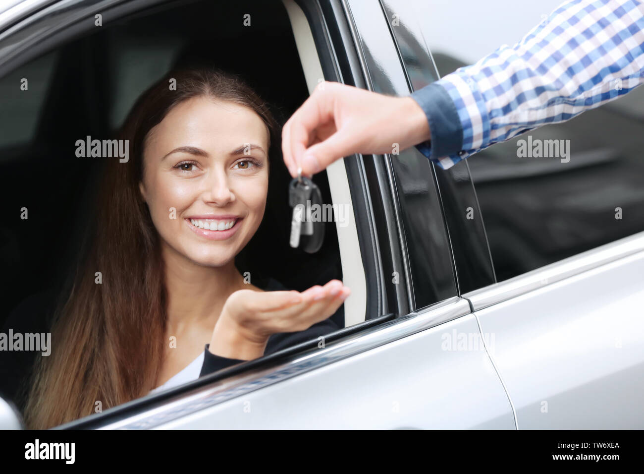 Junge Frauen, die Taste beim Sitzen auf dem Fahrersitz des Autos Stockfoto