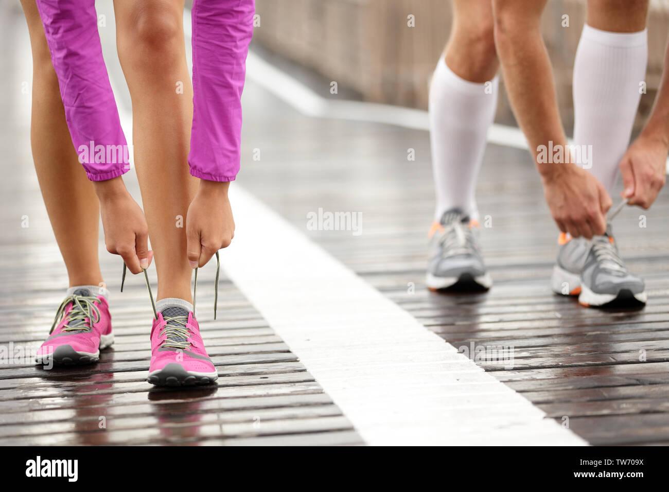 Runner Füße. Laufen Paar closeup von Laufschuhen. Frau barfuß laufen Schuhe im Vordergrund. Paar Joggen auf der Brooklyn Bridge, New York. Stockfoto