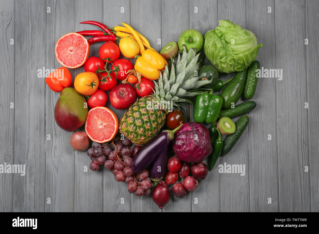 Kreative Zusammensetzung von Obst und Gemüse in Regenbogenfarben auf hölzernen Hintergrund, flach Stockfoto