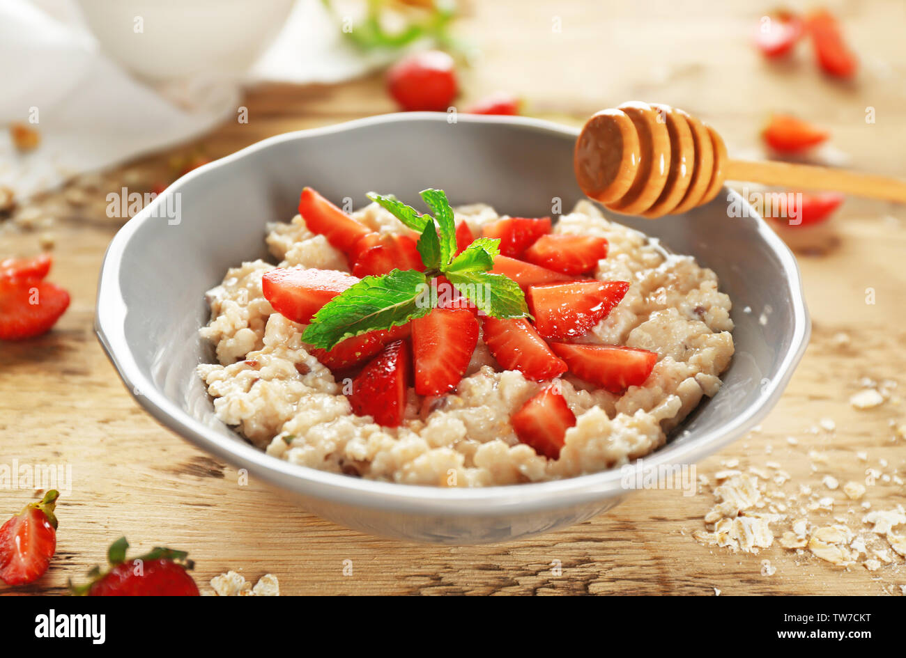 Leckere Haferflocken Porridge mit Erdbeeren in der Schüssel auf dem Tisch Stockfoto