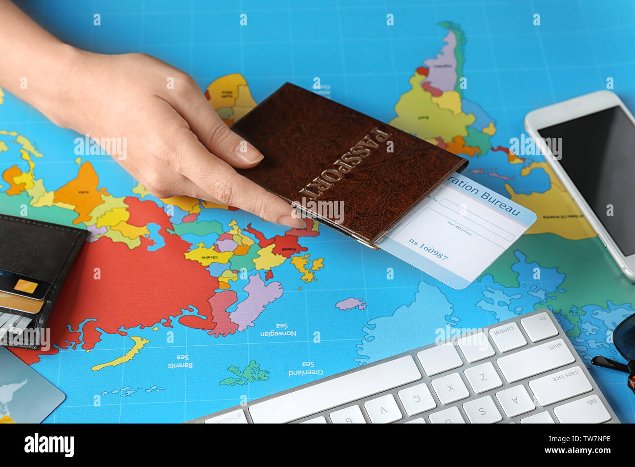 Frau mit Reisepass mit Anreise Karte auf Weltkarte Stockfoto