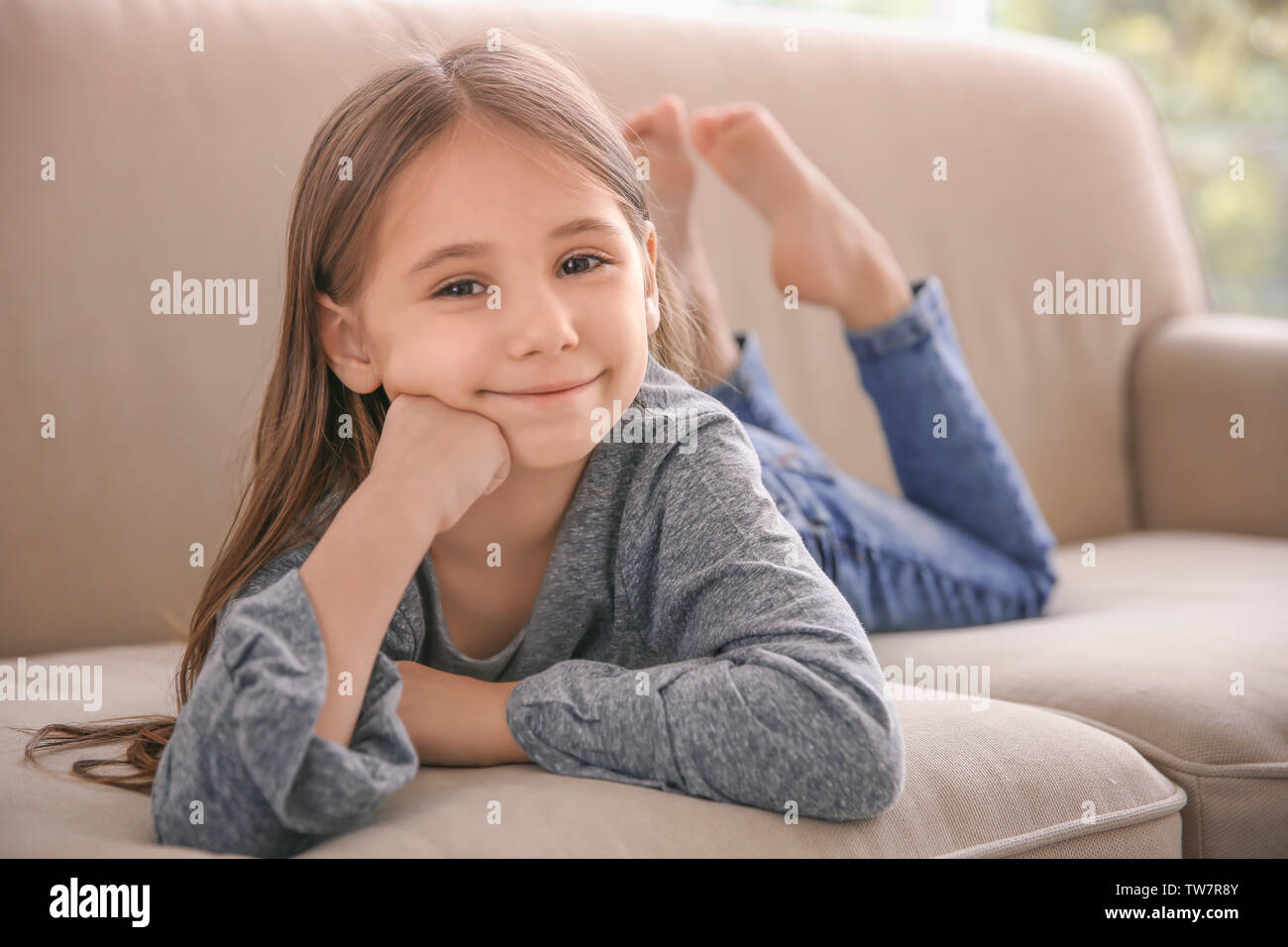 Süße kleine Mädchen auf dem Sofa zu Hause liegen Stockfoto