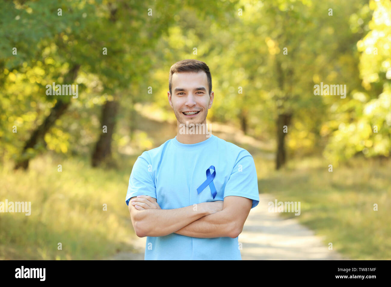 Junger Mann im t-shirt mit blauen Band im Freien. Prostatakrebsbewußtsein Konzept Stockfoto