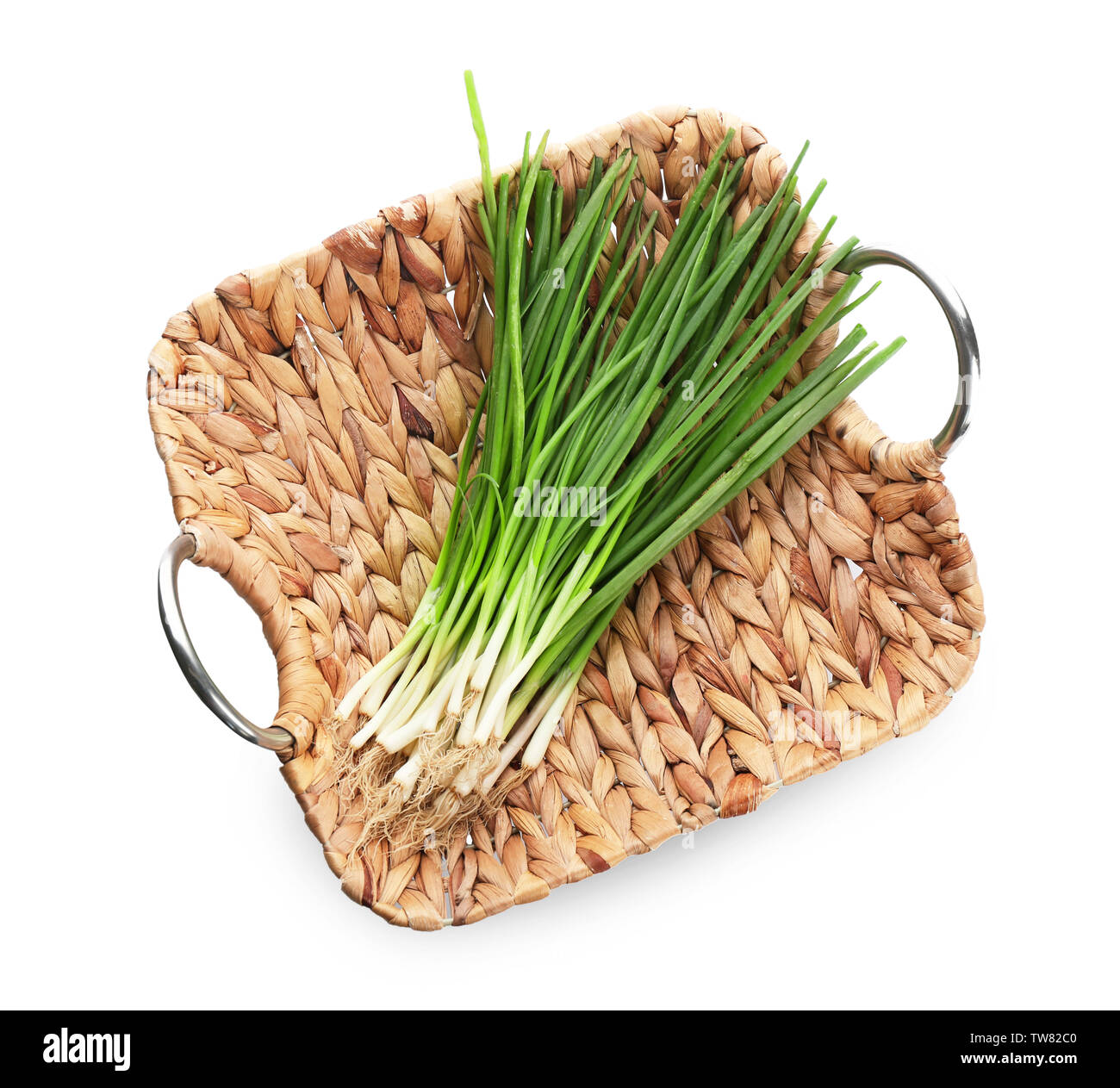 Wicker Fach mit grünen Zwiebeln auf weißem Hintergrund Stockfoto