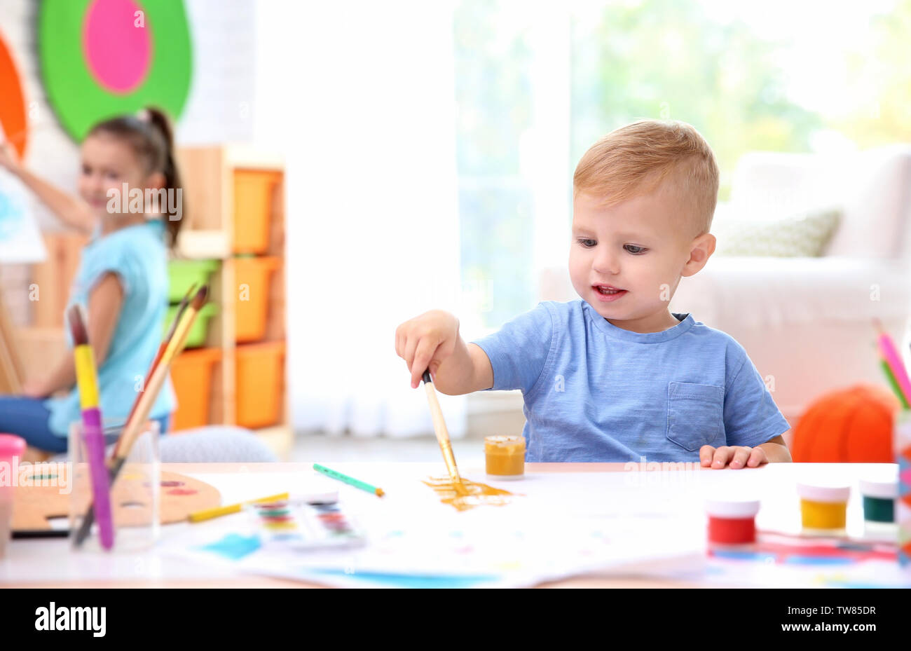 Little Boy und verschwommenes Mädchen Malerei im Innenbereich Stockfoto