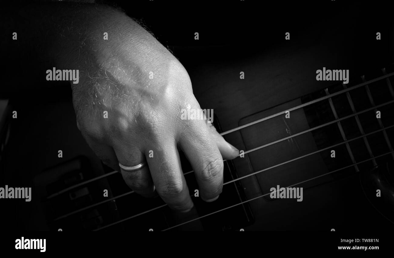 4 Strings vitange E-Bass Gitarre mit Händen spielen und anderen Perspektive Stockfoto