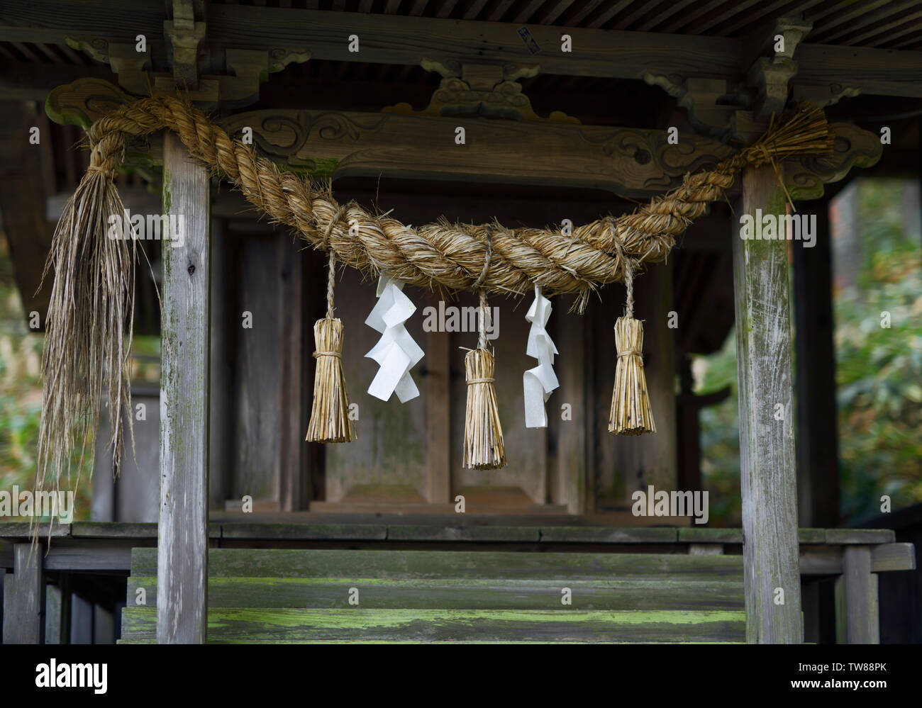 Ländliche Shinto Schrein detail, Shimenawa Seil und Papier Streamer, Shide, das Schmücken von Objekten. Stockfoto