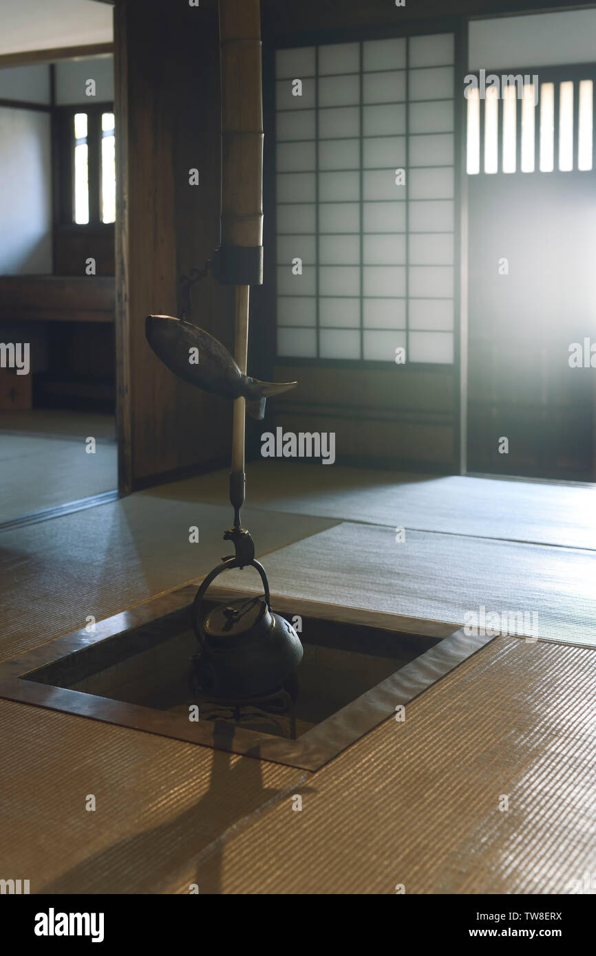 Japanische Tee Zimmer offene Feuerstelle, Irori, in die Bodenöffnung, mit einem Wasserkocher, Kama, und ein Fisch geformte Hebel einer pot Halter. Takayama, Japan Stockfoto