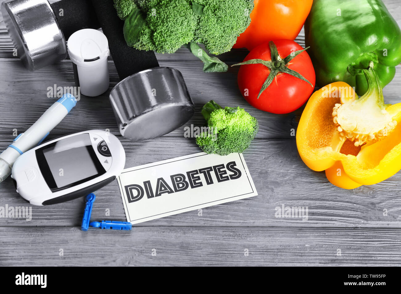 Zusammensetzung mit digitalen glucometer, Gemüse und Kurzhanteln auf Tisch. Diabetes Diät Stockfoto