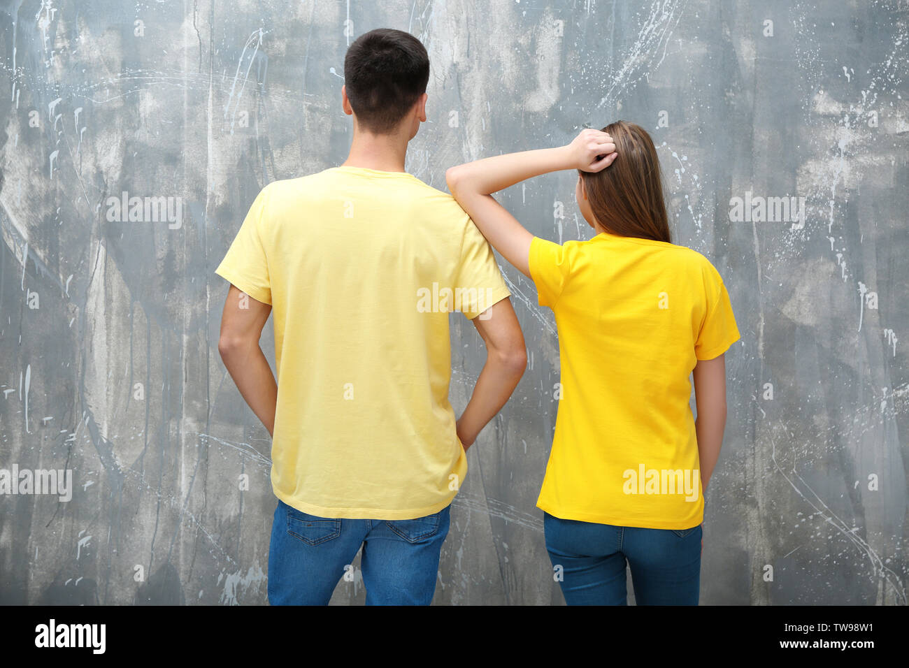 Junge Frau und Mann im gelben T-Shirts auf grunge Hintergrund. Mockup für Design Stockfoto