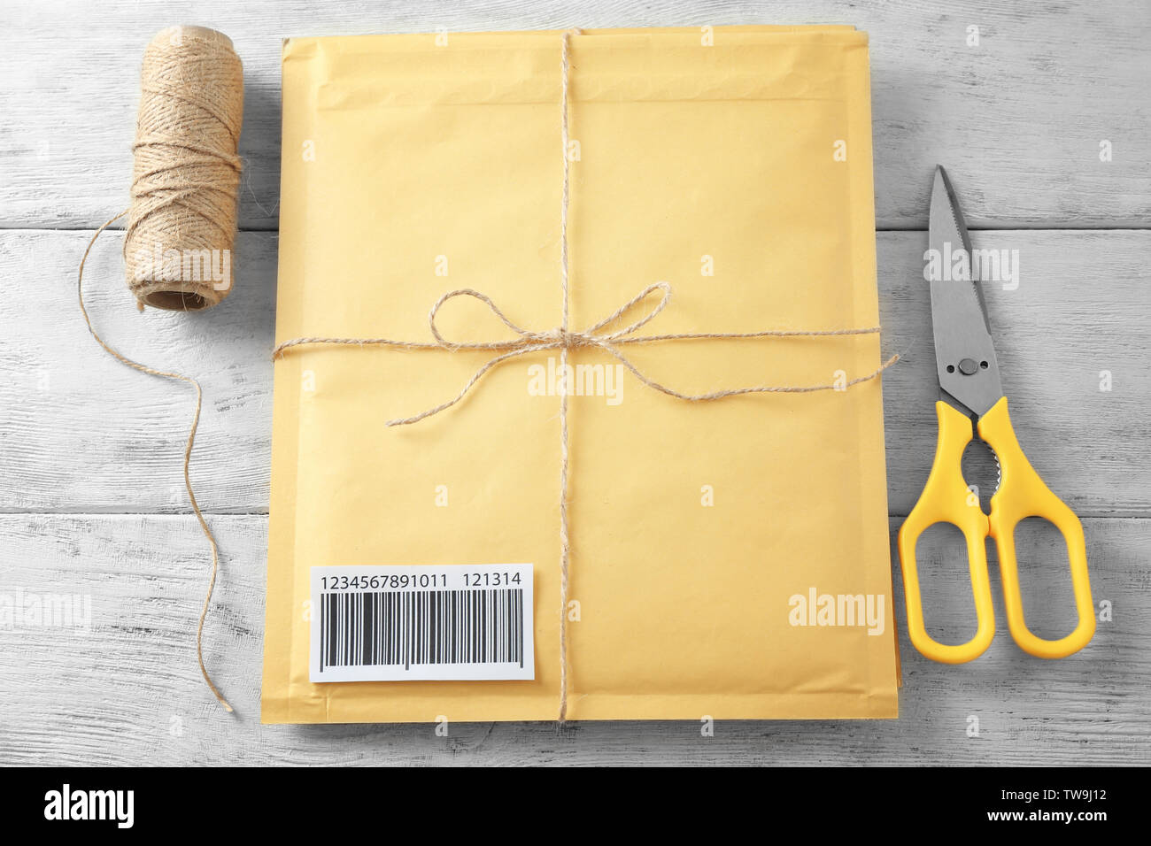 Geschenk gepolsterten Umschlag mit Tracking-nummer auf Holz- Hintergrund Stockfoto