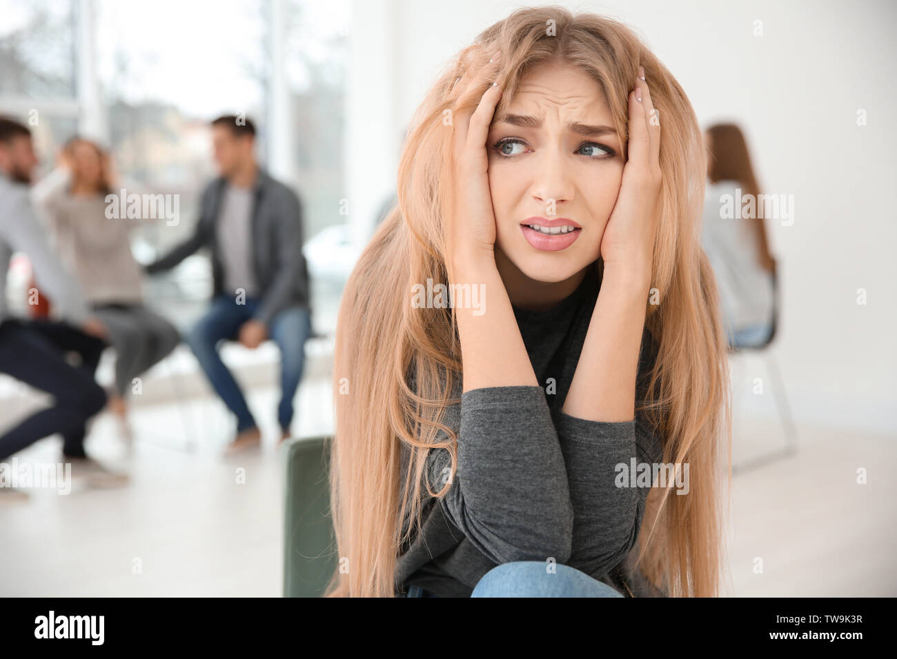 Betonte Frau während der gruppentherapie, innen Stockfoto