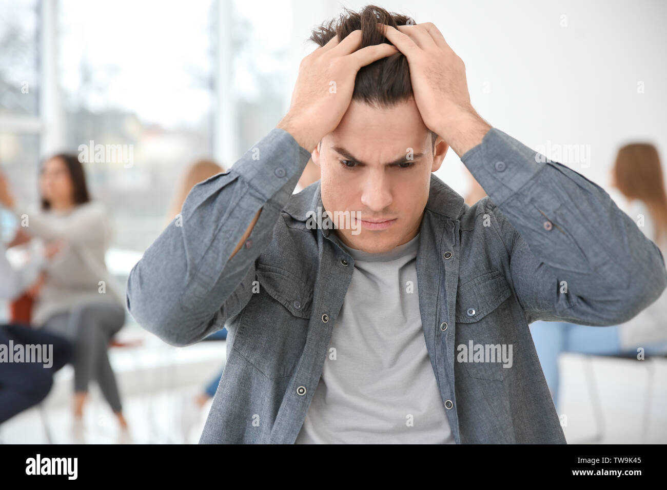 Betonte Mann während der Gruppe Therapie, innen Stockfoto