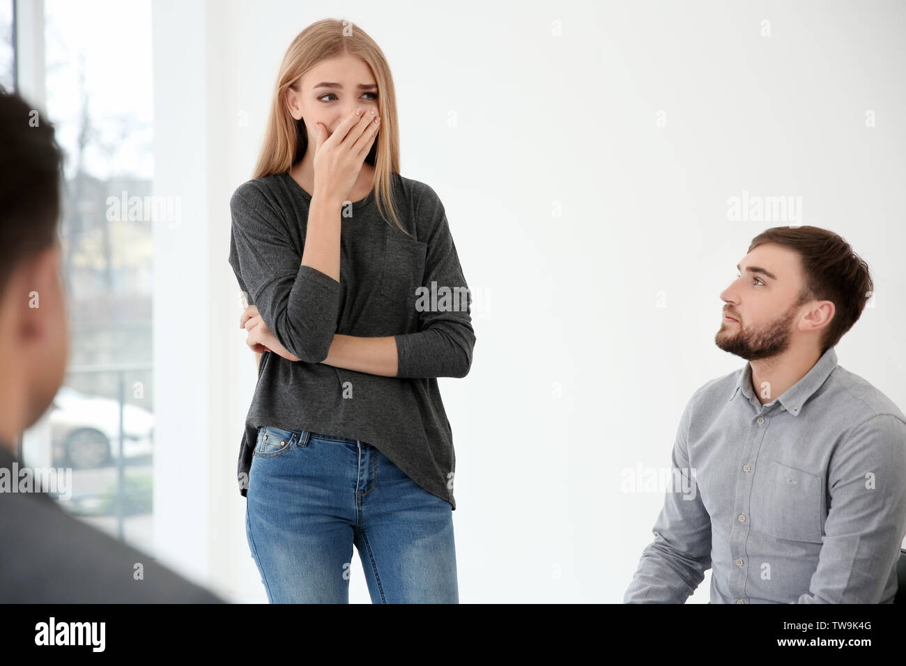 Junge Frau erzählt von ihren Problemen bei der Gruppe Therapie Stockfoto