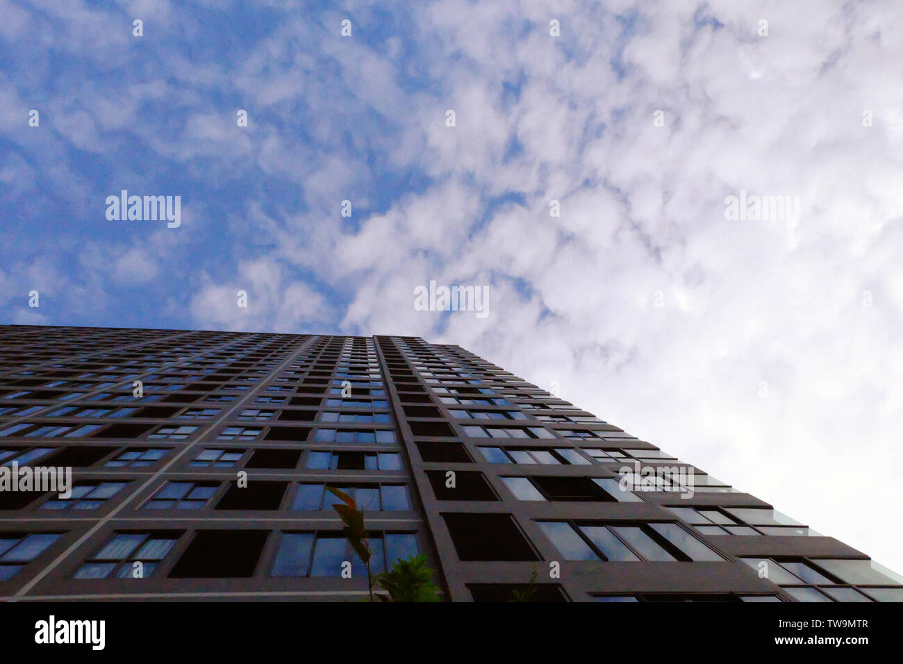 Skyscraper Bürogebäude mit Wolken Hintergrund. Modernes Gebäude Architektur und sunblue Himmel mit Wolken für den Sommer. Flauschige bewölkt Textur. Blaue Tonne Stockfoto