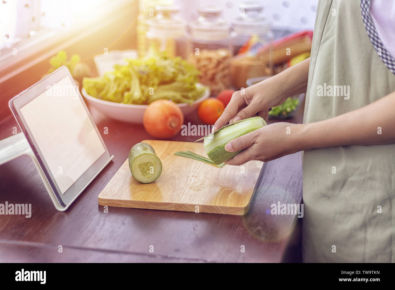 Weibliche Hand schneiden grünes Gemüse, Zutaten vorbereiten für das Kochen folgen Kochen online Video Clip auf der Website über Tablet. Kochen Inhalt auf intern Stockfoto