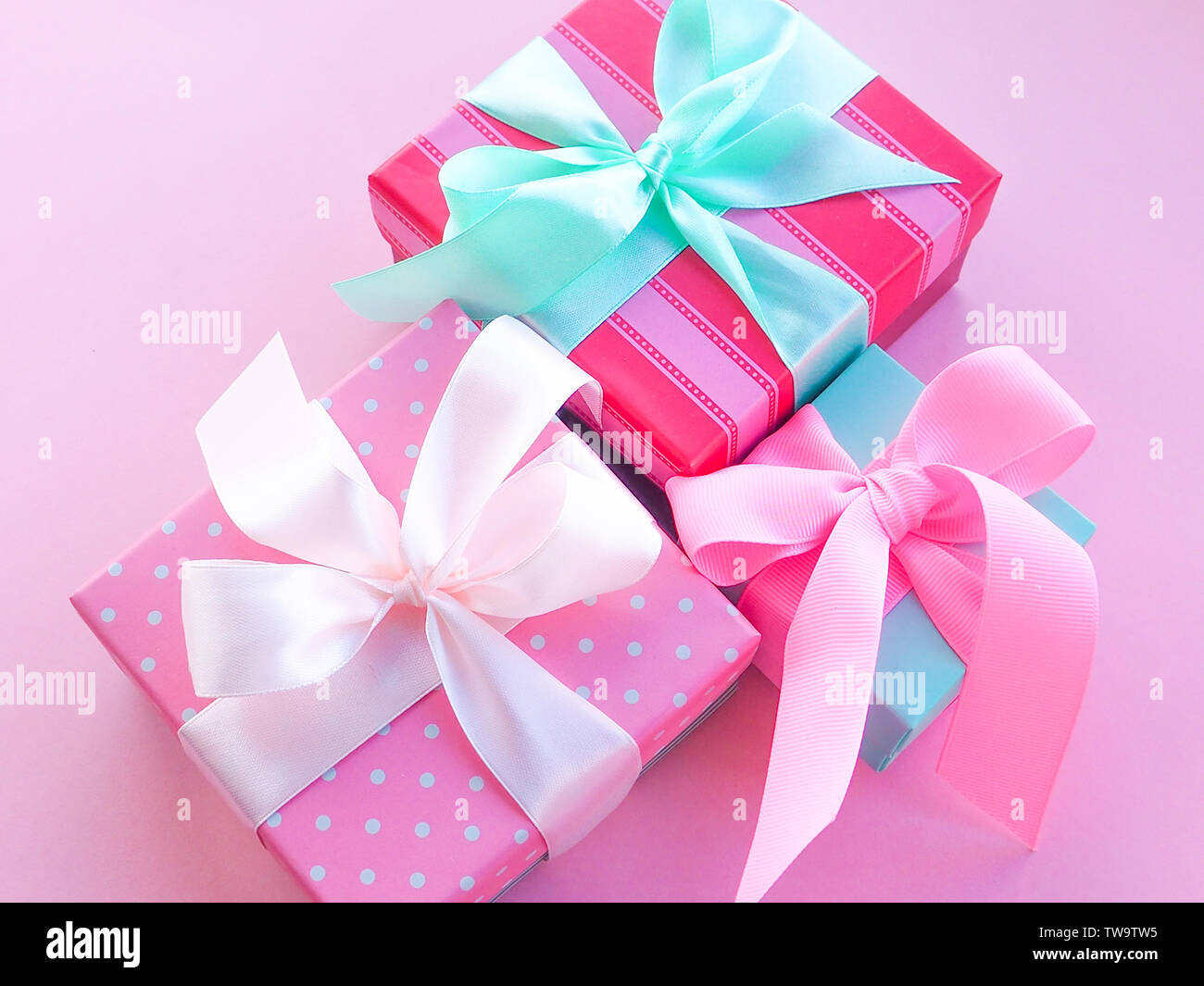 Geschenkbox mit bunten Satinband, rosa Hintergrund, Grüße zum Tag der Frauen, Muttertag, Valentinstag, Geburtstag, Weihnachten, Platz für Text Stockfoto