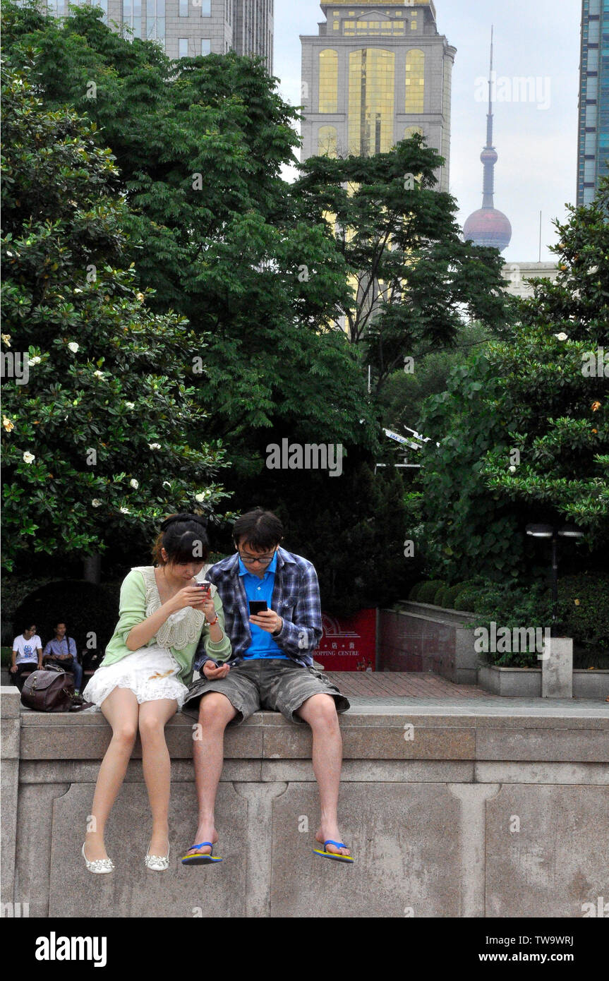 Chinesische Paar in ihren Handys absorbiert Stockfoto