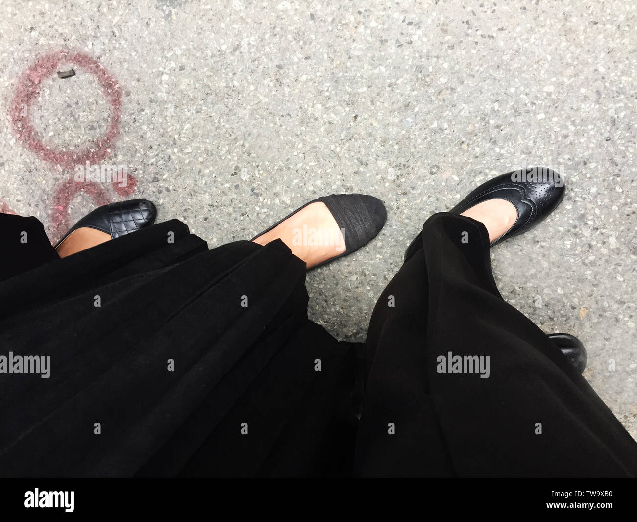 Schwarz High Heel auf Zement Hintergrund. Ansicht von oben schöne junge Frau mit schwarzen Schuhen auf Beton. Nahaufnahme der Beine und Füße für die Kleidung. Stockfoto