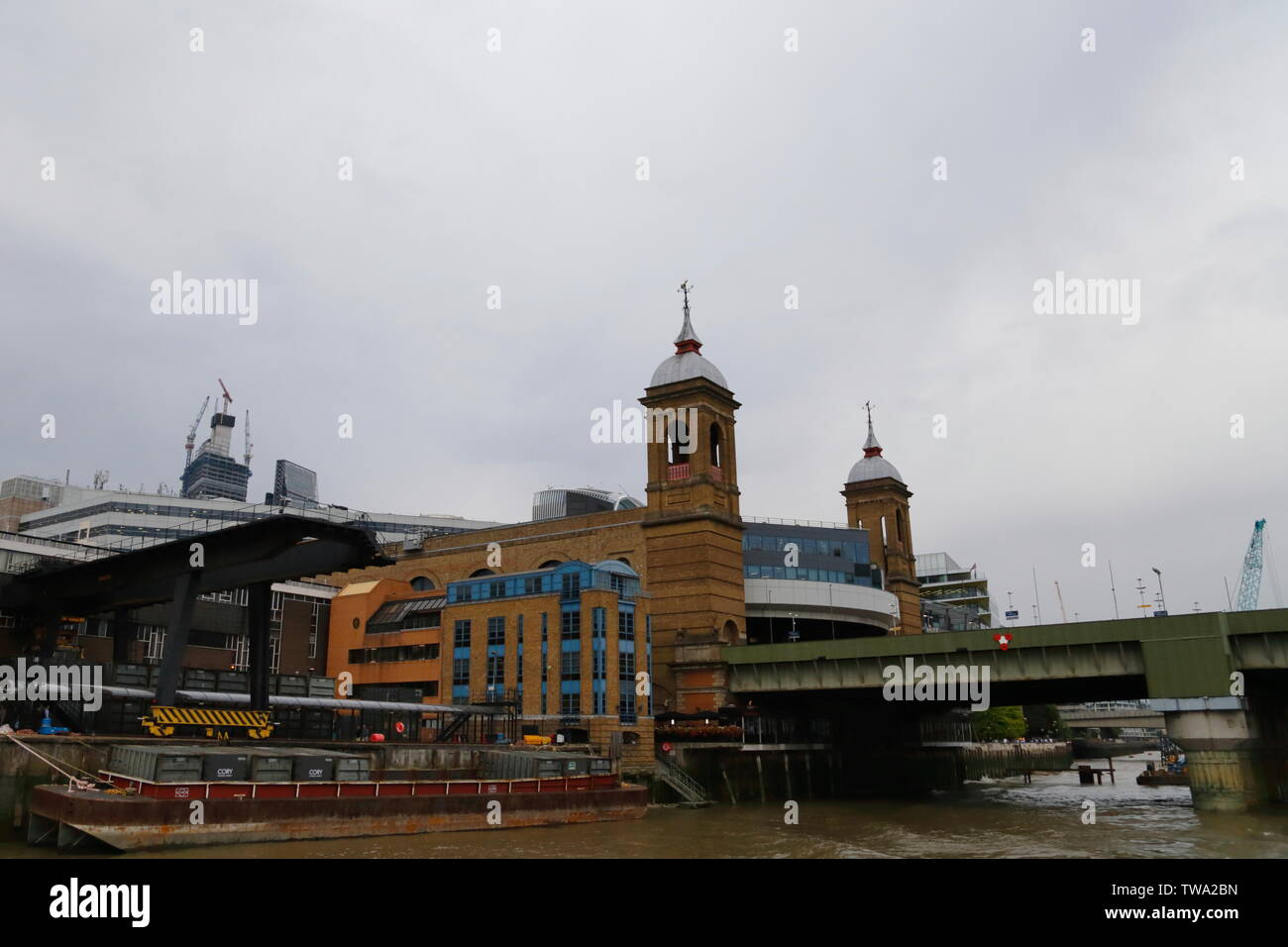 Ein braunes Ziegelgebäude mit Türmen und eine Brücke über die Themse in London, Vereinigtes Königreich. Stockfoto