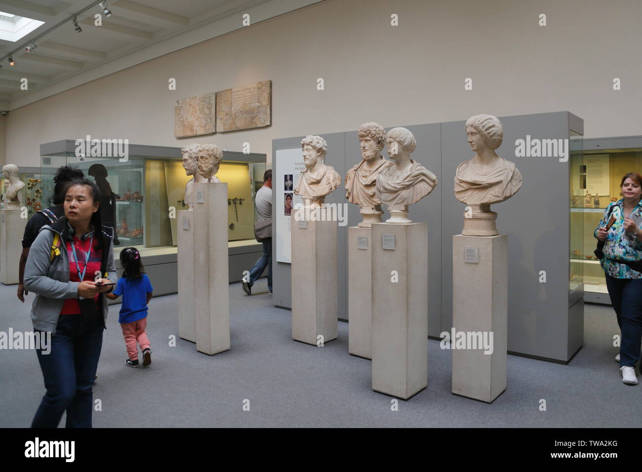 Die Besucher gehen vorbei an der Sammlung von alten Marmor römischen Büsten und Skulpturen auf Anzeige im British Museum in London, Vereinigtes Königreich. Stockfoto