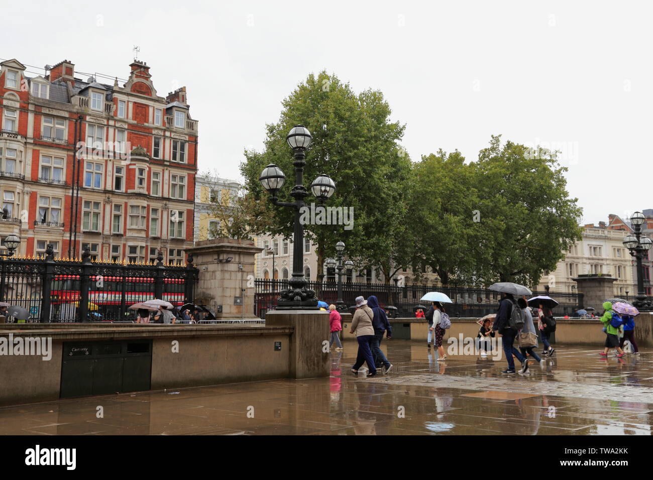 Die Leute gehen weg, das British Museum und in Richtung Tor und Exit gehen, im Regen, in Bloomsbury, London, Vereinigtes Königreich. Stockfoto