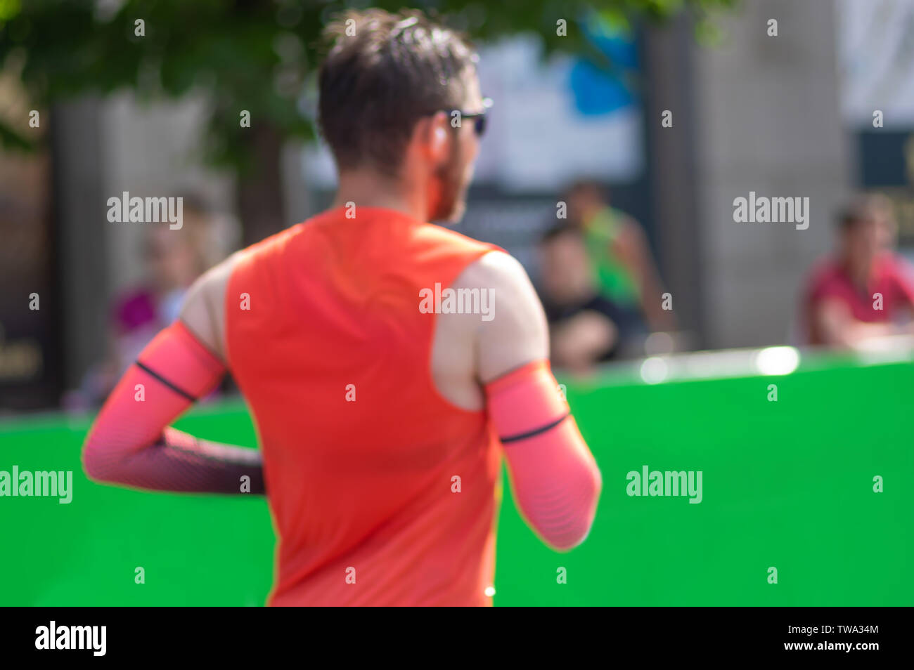 Blurry sport Hintergrund - obere Hälfte des Menschen Körper das Tragen der roten Hemd und Ärmel, die auf einer Straße Stockfoto