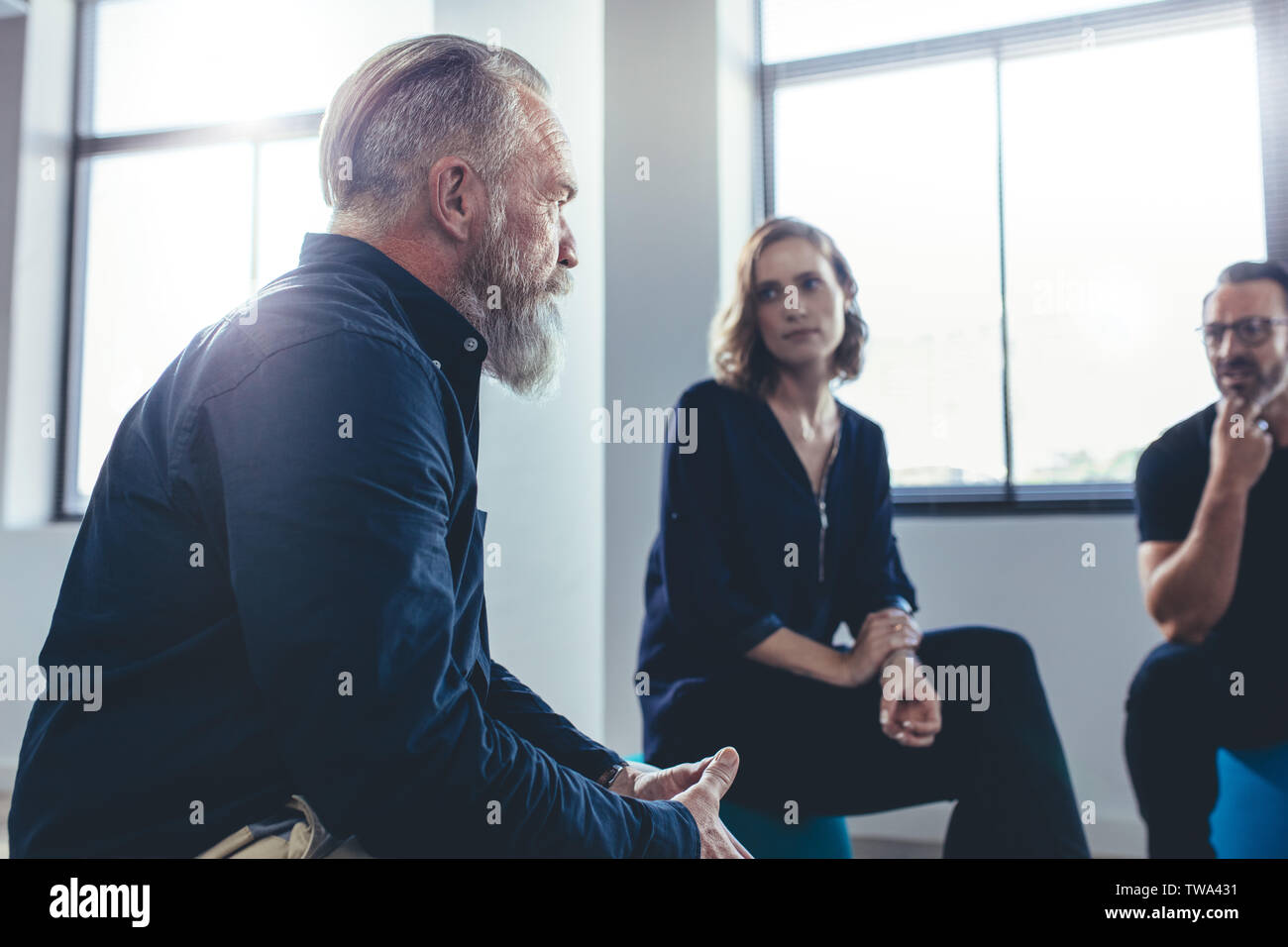 Ältere Unternehmer beraten, um sein Team in einem Büro treffen. Business Team zusammen zu sitzen und zu diskutieren. Stockfoto