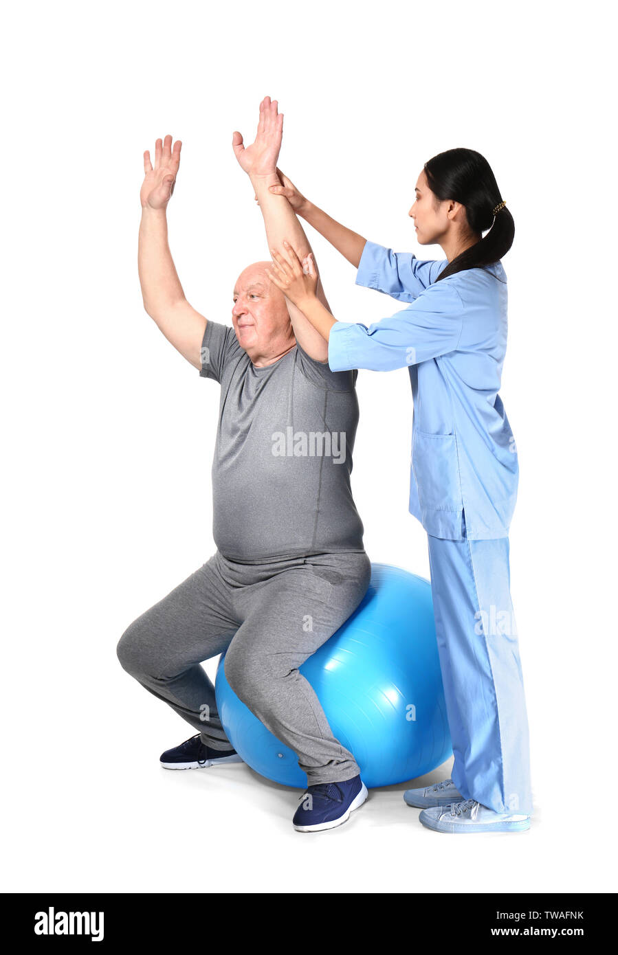 Jungen asiatischen Physiotherapeuten arbeiten mit älteren Menschen auf weißem Hintergrund Stockfoto