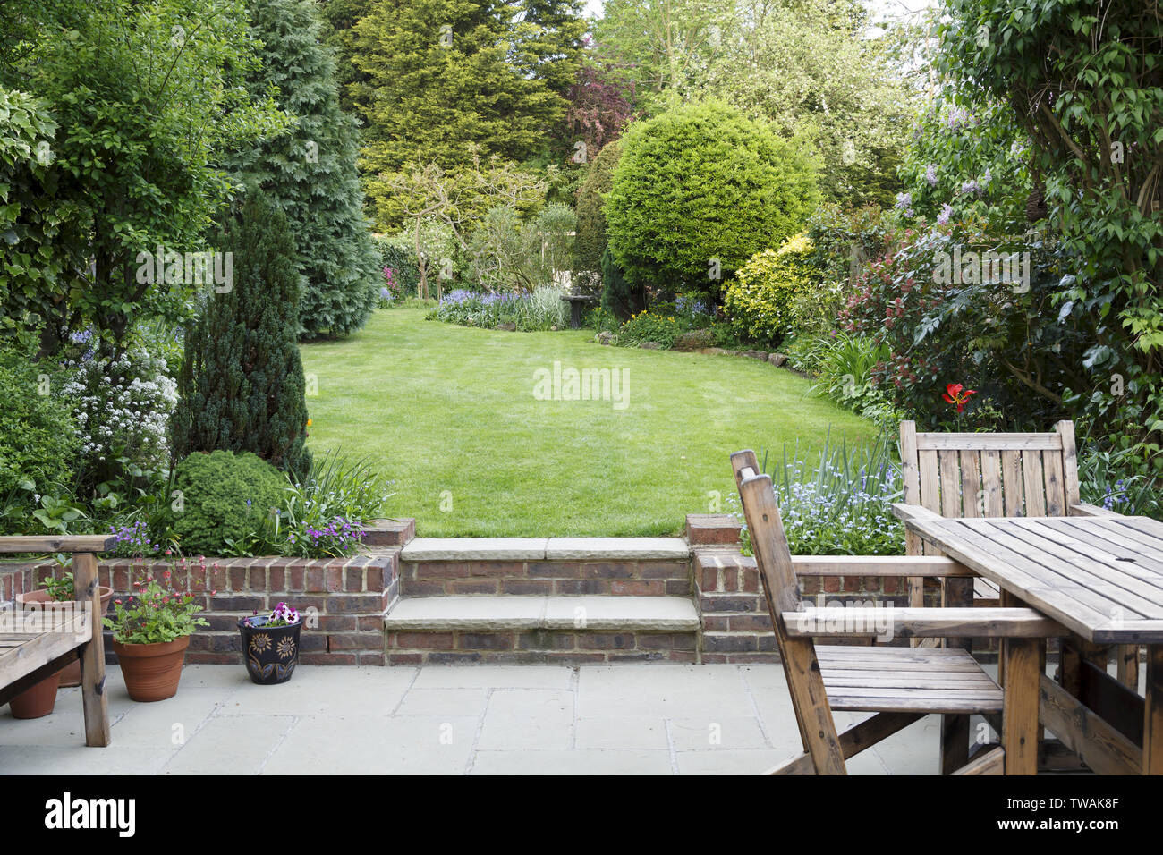 Garten Terrasse mit Gartenmöbeln und Rasen in einem typischen Englischen Garten in London, Großbritannien Stockfoto