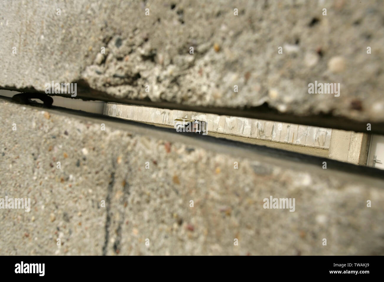 Blick durch die Lücken in der Berliner Mauer über eine erhaltene Abschnitt des berüchtigten Todesstreifen, an der Bernauer Straße, Berlin, Deutschland. Stockfoto