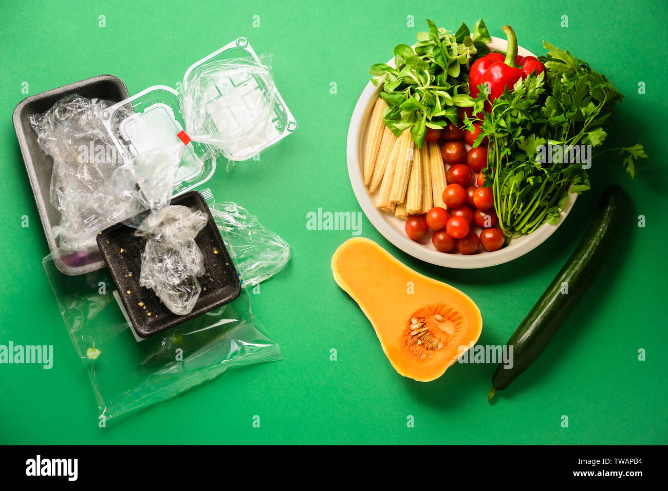 Verwendete Plastik einweg Lebensmittel und frisches Gemüse auf grünem Hintergrund. Kunststoffabfälle, Recycling Konzept. Ansicht von oben, flach Stockfoto