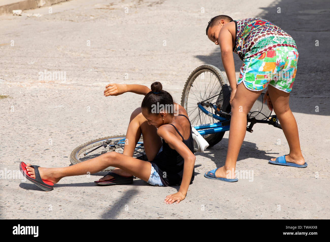 Ein kubanischer Bruder und Schwester fällt ihr Fahrrad in der Mitte der Straße in Trinidad, Kuba Stockfoto