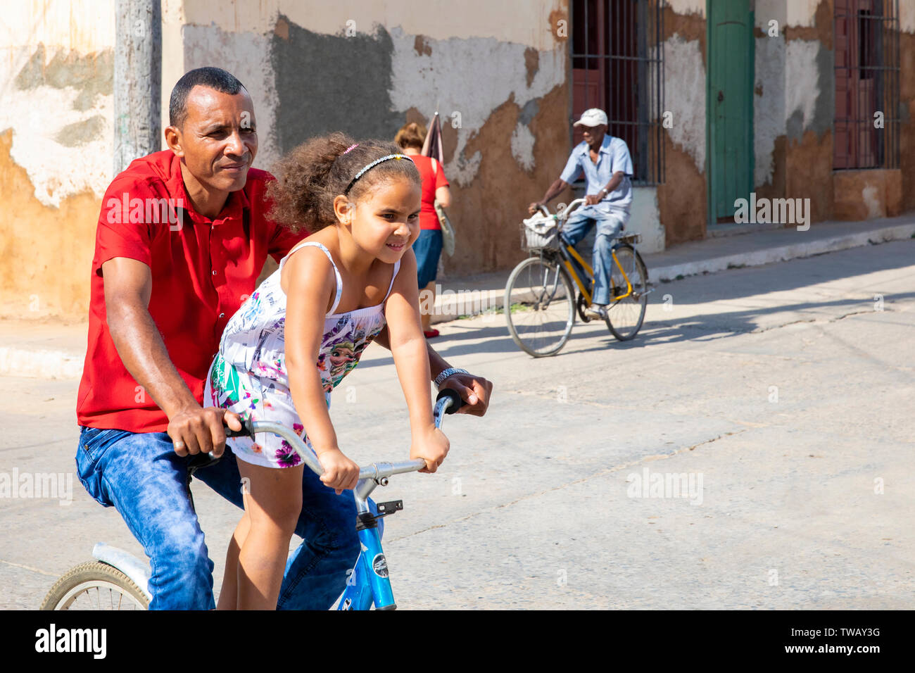 Ein kubanischer Vater mit seinem dauther auf seinem Fahrrad mit ihm in Trinidad, Kuba Stockfoto