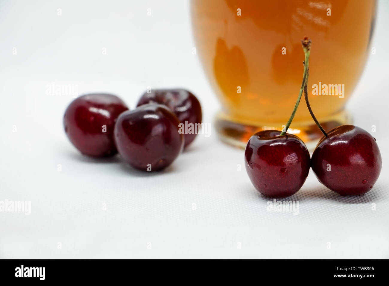 Trauben von süßkirschen und eine Flasche cherry gesunden Saft. Sommer und Herbst Früchte. Kaltes Erfrischungsgetränk aus reife Beeren. Cherry Kompott. Stockfoto