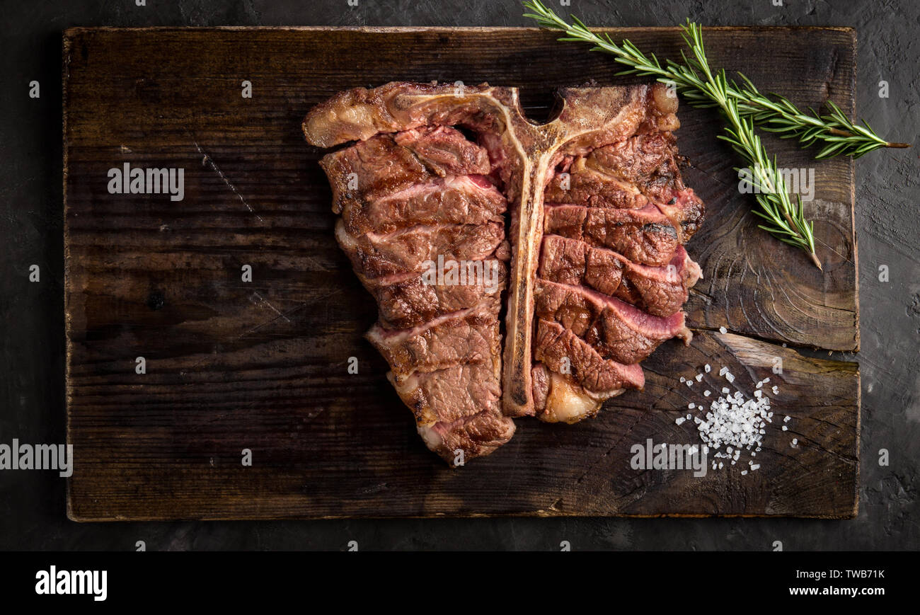 Zu Steak vom Grill ist auf ein Stück Holz Brett. rustikalen Stil geschnitten, Ansicht von oben Stockfoto