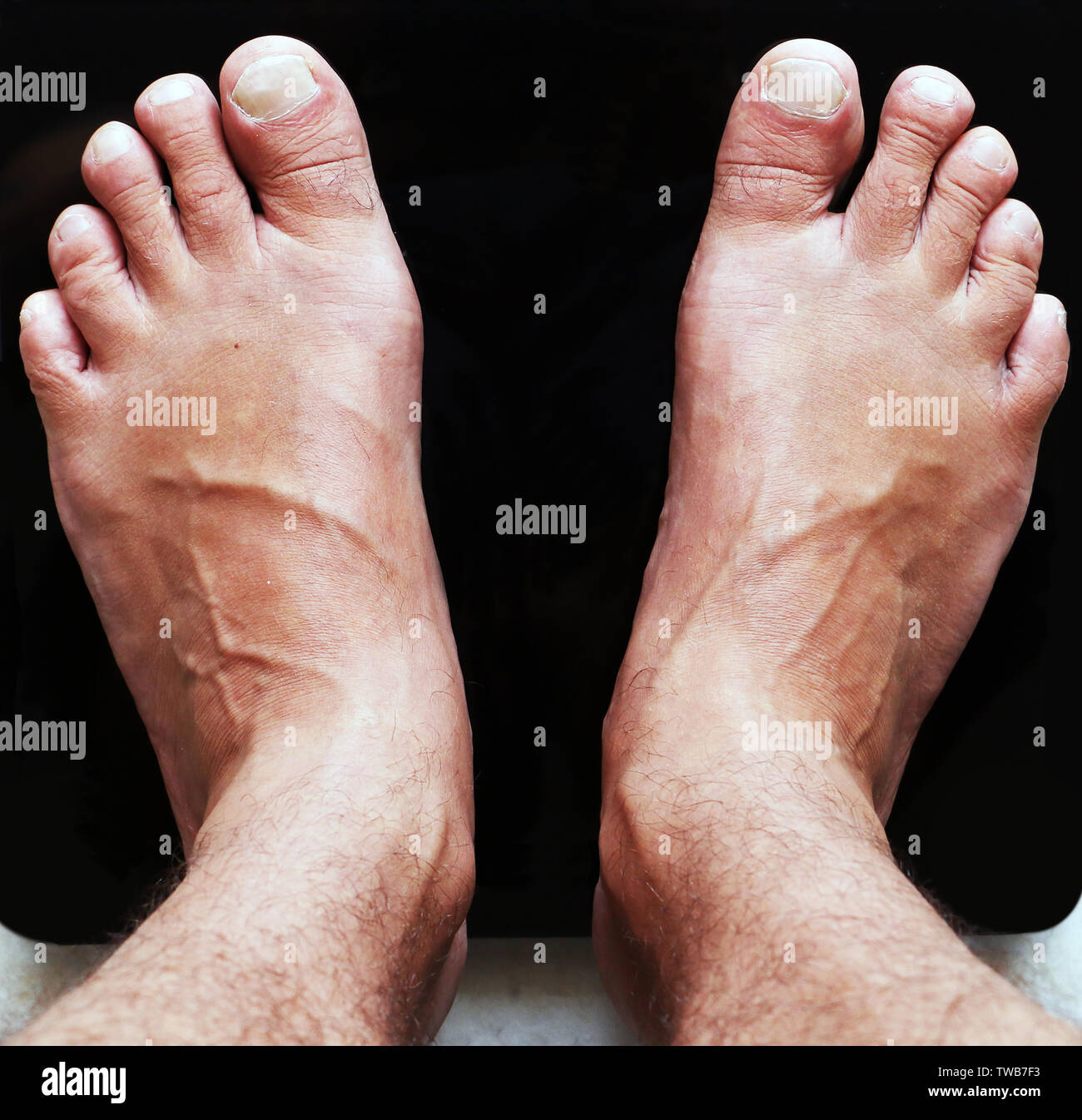 Nahaufnahme der männlichen Füße auf Schwarz digital Stock Glasmaßstäbe. Ernährung und Körpergewicht. Von oben nach unten anzeigen. Sport und Lifestyle Konzept. Mann, der auf der Skala. Stockfoto