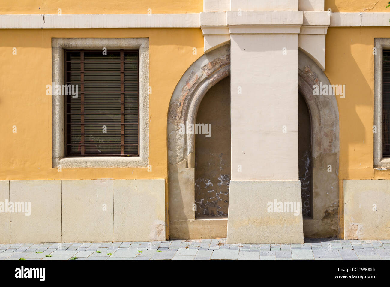 Mittelalterliche Reste von Torbogen in gelber Mauer, Koszeg, Ungarn Stockfoto
