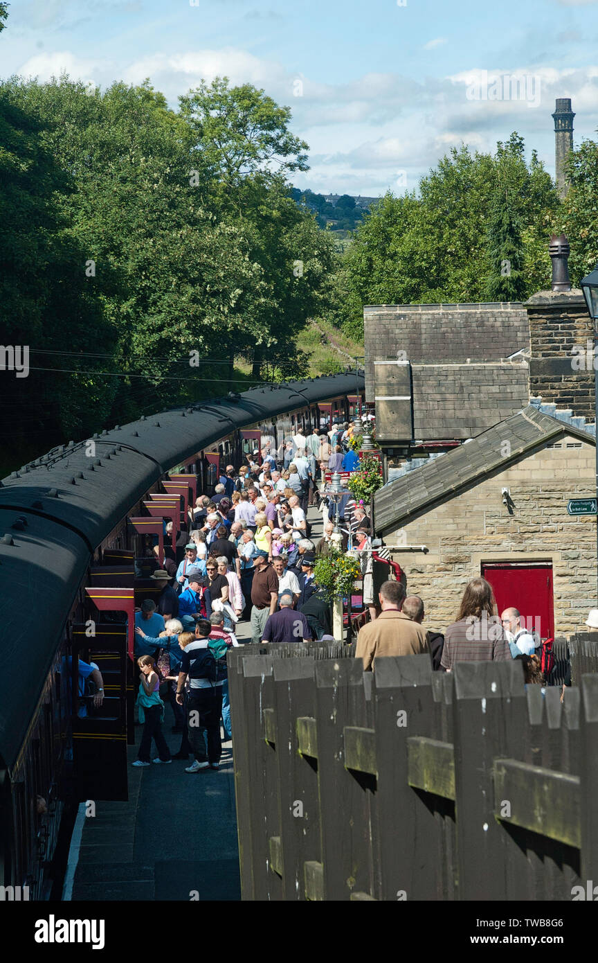 Eine Masse von Fluggästen auf der Plattform neben dem Dampfzug an Haworth Bahnhof, auf Keighley und Worth Valley Railway Stockfoto