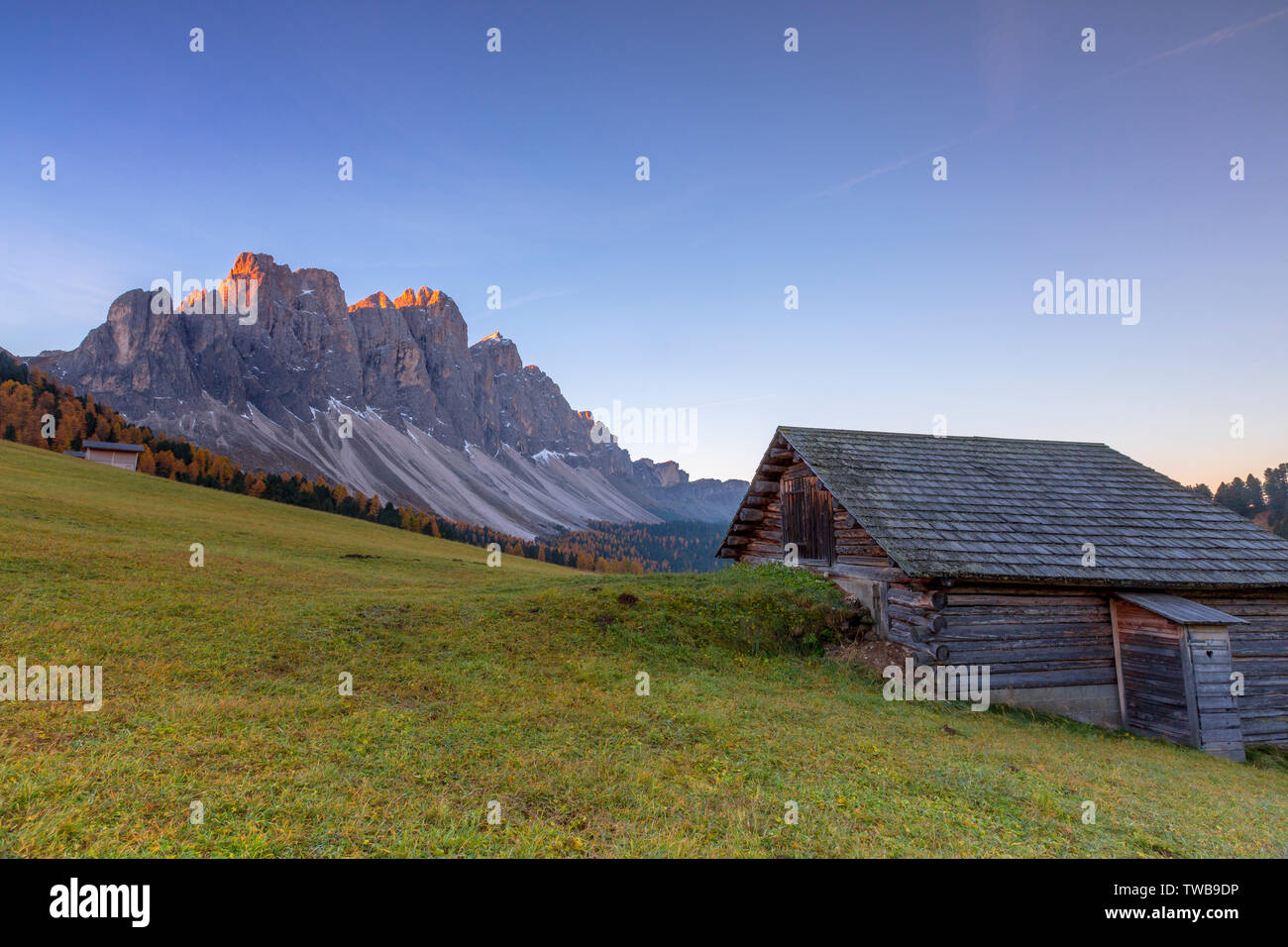 Sonnenaufgang auf die Geisler Spitzen aus Holz Chalet zur gampenalm, Dolomiten, Funes, Provinz Bozen, Südtirol, Italien Stockfoto