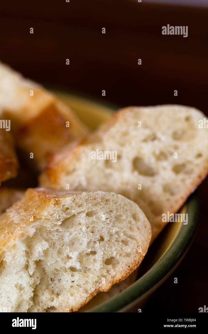 Frisches Brot schneiden und in eine Schüssel zum Abendessen Stockfoto