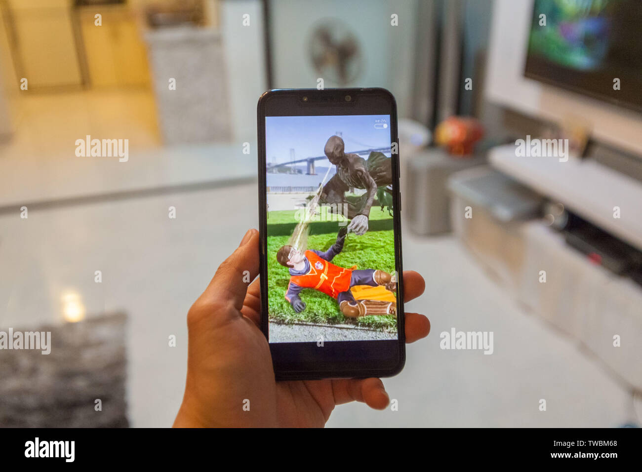 Kuala Lumpur, Malaysia, Juni 2019: ein Mann hält eine Unbranded phone Spielen ein Augmented Spiel von Niantic die Harry Potter Zauberer Unite Stockfoto