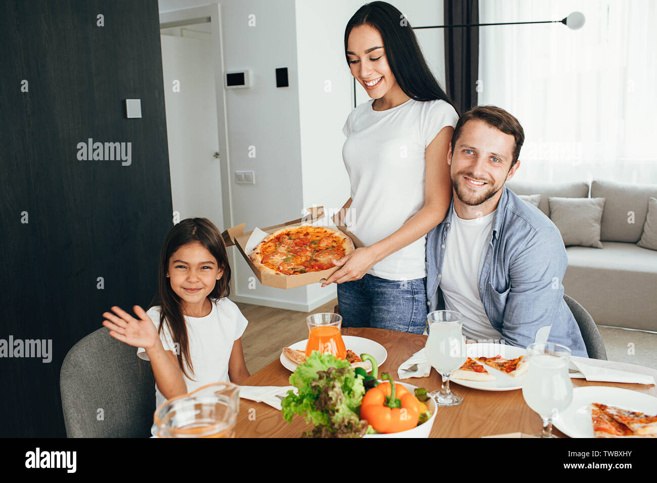Glücklich, multi-ethnische Familie, Mutter, Vater und Tochter beim Abendessen. Das Essen lecker Pizza mit Familie Stockfoto