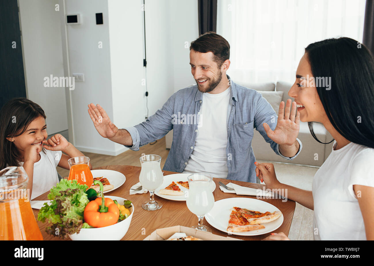 Familie, Mutter, Vater und Tochter beim Essen. Essen essen hausgemachte Pizza zu Hause Stockfoto