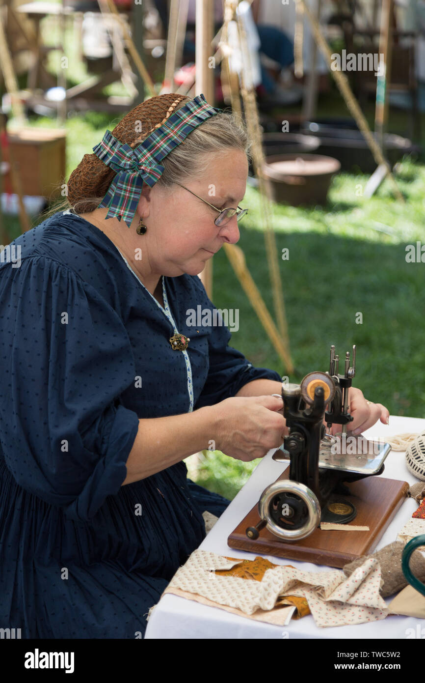 Eine Frau im Kleid zeigt eine antike Nähmaschine, während in der Johnny Appleseed Festival in Fort Wayne, Indiana, USA. Stockfoto