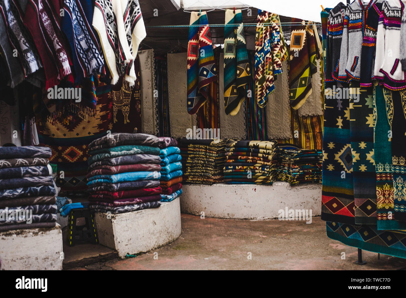 Überfüllte Ställe mit indigenen Gewebe und Souvenirs in Otavalo, Ecuador, einer der größten handwerklichen Märkte in Südamerika Stockfoto